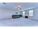 Open concept bonus room with gray carpeting, neutral walls, and large modular couch at 22167 Tucana Way, Land O Lakes, FL 34637