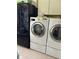Laundry room featuring front load washer, dryer, and built in cabinets at 2510 Cypress Bend E Dr, Clearwater, FL 33761