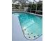Screened-in pool features crystal-clear water and a tiled border, creating a refreshing outdoor oasis at 2510 Cypress Bend E Dr, Clearwater, FL 33761
