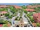 Aerial view of a community entrance featuring lush landscaping, a fountain, and red tile roofs at 2773 Via Cipriani # 1330B, Clearwater, FL 33764