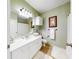 Well-lit bathroom featuring a double sink vanity, framed art, and neutral wall color at 2773 Via Cipriani # 1330B, Clearwater, FL 33764