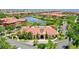 Aerial view of a clubhouse with a distinctive roof, surrounded by lush landscaping and manicured grounds at 2773 Via Cipriani # 1330B, Clearwater, FL 33764