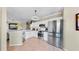 Bright kitchen featuring stainless steel appliances, white cabinetry, and modern lighting at 2773 Via Cipriani # 1330B, Clearwater, FL 33764
