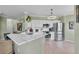Open kitchen with stainless steel appliances, white cabinets, and a breakfast bar at 2773 Via Cipriani # 1330B, Clearwater, FL 33764