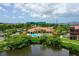Aerial view of a clubhouse and pool with a view of the water at 2773 Via Cipriani # 1330B, Clearwater, FL 33764
