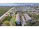 Expansive aerial view of Bayshore community featuring lush landscaping, pond, and partial view of the bay and bridge in the distance at 31 Estuary Trl, Clearwater, FL 33759