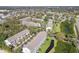 Aerial view highlighting the neighborhood, with townhomes, well-maintained landscapes, and surrounding trees at 31 Estuary Trl, Clearwater, FL 33759