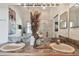 Bathroom vanity with dual sinks, decorative accents, and a large mirror with ample lighting at 31 Estuary Trl, Clearwater, FL 33759