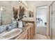 Bathroom vanity with dual sinks, decorative accents, and a large mirror with ample lighting at 31 Estuary Trl, Clearwater, FL 33759