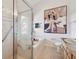Well-appointed bathroom featuring a glass-enclosed shower and bathtub, and neutral tile flooring at 31 Estuary Trl, Clearwater, FL 33759