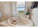 Bright bathroom showcasing a soaking tub with garden view, a shower, and relaxing atmosphere at 31 Estuary Trl, Clearwater, FL 33759