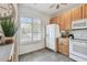 Bright kitchen featuring tile floors, wood cabinets, and a white refrigerator at 31 Estuary Trl, Clearwater, FL 33759