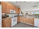 Well-lit kitchen with light wood cabinets, white appliances, and gray countertops at 31 Estuary Trl, Clearwater, FL 33759
