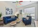 Bright living room with a comfortable blue sofa and a colorful ceiling fan, perfect for relaxation and entertainment at 31 Estuary Trl, Clearwater, FL 33759