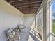 View of the shaded patio featuring two cozy wicker chairs and a screened-in enclosure at 31 Estuary Trl, Clearwater, FL 33759