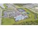 Aerial view of a neighborhood clubhouse, community pool, tennis courts, and parking lot at 32684 Tamarind Grove Ln, Wesley Chapel, FL 33543