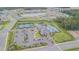 Aerial view of the community amenity center including a pool, tennis courts, parking and a clubhouse at 32684 Tamarind Grove Ln, Wesley Chapel, FL 33543