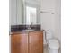 Bathroom with a dark wood vanity, granite countertop, and a built-in mirror at 32684 Tamarind Grove Ln, Wesley Chapel, FL 33543