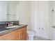 Bathroom featuring a granite countertop, framed mirror, a sink with a brushed nickel faucet and tiled floors at 32684 Tamarind Grove Ln, Wesley Chapel, FL 33543