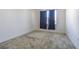Bedroom featuring neutral walls and carpet, with a large window dressed with dark blue curtains at 32684 Tamarind Grove Ln, Wesley Chapel, FL 33543