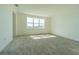 Well-lit bedroom with neutral carpeting, a window and ample space for personalization at 32684 Tamarind Grove Ln, Wesley Chapel, FL 33543