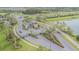 View of the neighborhood entrance with gates, landscaping, and palm trees at 32684 Tamarind Grove Ln, Wesley Chapel, FL 33543