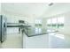 Bright kitchen featuring a large island, modern stainless steel appliances, and view to the lake at 32684 Tamarind Grove Ln, Wesley Chapel, FL 33543