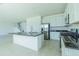 Modern kitchen featuring a large island with dark countertop, white cabinets, and stainless steel appliances at 32684 Tamarind Grove Ln, Wesley Chapel, FL 33543