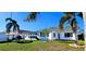 The cozy backyard features an outdoor firepit, comfortable seating, manicured landscaping, and mature palms at 3506 Moog Rd, Holiday, FL 34691