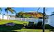 Expansive backyard featuring green grass, an outdoor seating area, and a fire pit for entertaining at 3506 Moog Rd, Holiday, FL 34691