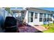 Back of house patio with outdoor seating area, grill, and access to the sunroom at 3506 Moog Rd, Holiday, FL 34691