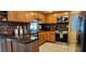 Kitchen with stainless steel appliances, wood cabinets, granite countertops, tile flooring, and backsplash at 3506 Moog Rd, Holiday, FL 34691
