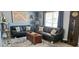 Cozy living room featuring dark leather couches, rug, and a grandfather clock at 3506 Moog Rd, Holiday, FL 34691