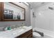Bathroom featuring stylish white tiled walls in the shower/bath and a vanity with a light marble countertop at 423 Shaddock St, Tarpon Springs, FL 34689