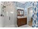 Stylish bathroom with updated vanity, glass shower, and unique wallpaper at 423 Shaddock St, Tarpon Springs, FL 34689