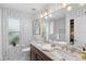 Double sink vanity, updated fixtures, and patterned wallpaper in this charming bathroom at 423 Shaddock St, Tarpon Springs, FL 34689