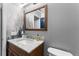 Bathroom featuring a wood vanity with light marble countertop, fog-themed wall paper, and a sleek sink fixture at 423 Shaddock St, Tarpon Springs, FL 34689