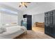 Bright bedroom with a large window and wooden floors, along with stylish blue dresser and a doorway to another room at 423 Shaddock St, Tarpon Springs, FL 34689