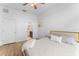 Comfortable bedroom featuring wood floors, a ceiling fan and neutral-toned bedding, plus an attached bathroom for convenience at 423 Shaddock St, Tarpon Springs, FL 34689