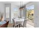 Dining area with modern light fixture, table for four, and sliding door access to the balcony at 423 Shaddock St, Tarpon Springs, FL 34689