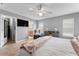 Spacious main bedroom featuring wood floors, a ceiling fan, a reading chair, and an adjoining bathroom and closet at 423 Shaddock St, Tarpon Springs, FL 34689