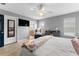 Spacious main bedroom featuring wood floors, a ceiling fan, a reading chair, and an adjoining bathroom and closet at 423 Shaddock St, Tarpon Springs, FL 34689