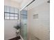 Modern bathroom shower with glass doors, subway tile, and a storage nook at 4238 Brentwood Park Cir, Tampa, FL 33624