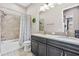 Well-lit bathroom featuring a double vanity, a shower-tub combo with tile surround, and modern fixtures at 4495 Casella Dr, Wesley Chapel, FL 33543