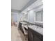 Bathroom with double sinks, dark cabinets, neutral walls, and a decorative framed mirror at 4588 Baycedar Ln, Sarasota, FL 34241