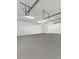 Spacious garage with concrete flooring, overhead lighting and storage racks that offers ample room for parking and projects at 4588 Baycedar Ln, Sarasota, FL 34241