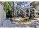 Backyard landscape featuring a screened-in porch and tropical greenery, and a white rock ground covering at 4967 162Nd N Ave, Clearwater, FL 33760