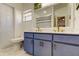 Clean bathroom featuring a toilet and a double sink vanity with blue cabinets and gold fixtures at 4967 162Nd N Ave, Clearwater, FL 33760
