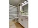 Bright bathroom featuring white cabinets, gold hardware, decorative shower curtain, and a modern sink at 4967 162Nd N Ave, Clearwater, FL 33760