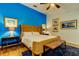 Bright bedroom with blue accent wall, wicker bed frame and foot bench over a stylish rug at 4967 162Nd N Ave, Clearwater, FL 33760